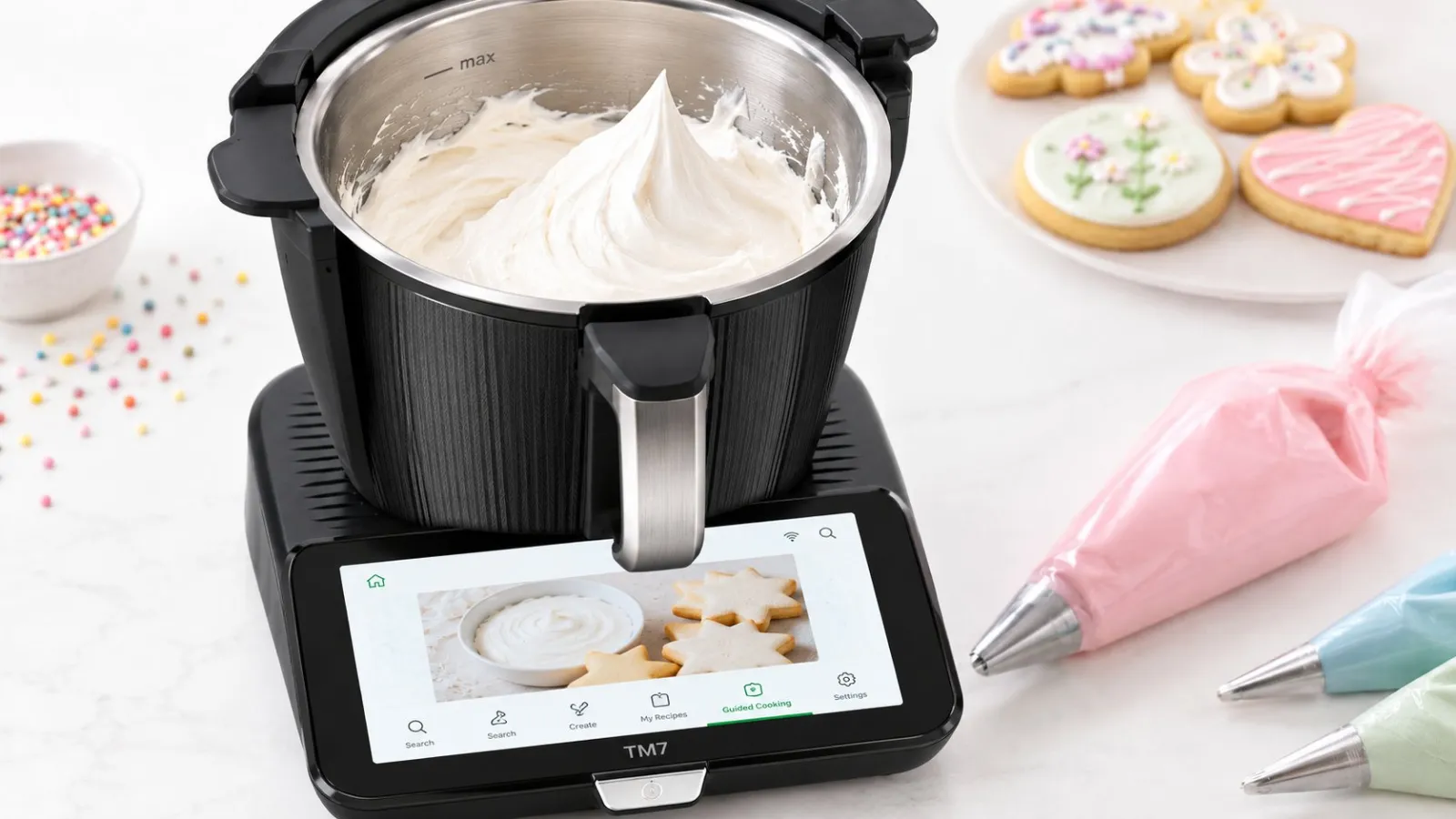 Vegan royal icing whipped in the Thermomix TM7 bowl, with decorated sugar cookies and piping bags