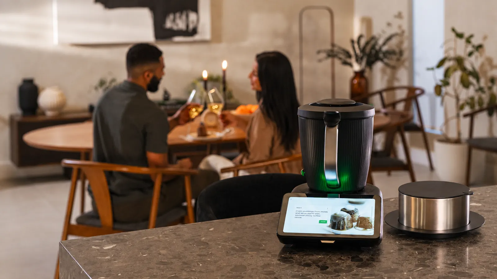 Couple enjoying dinner at home with the Thermomix TM7 on the kitchen counter